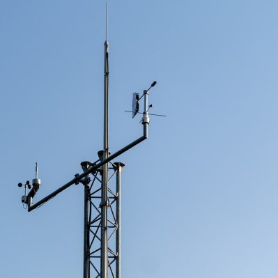 Communication antenna pole stands against clear blue sky